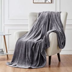 a white chair with a gray blanket on it