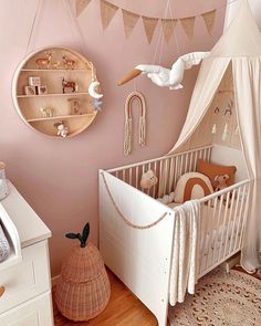 a baby's room with pink walls and white furniture