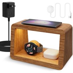 an electronic device is sitting on top of a wooden stand with ear buds and plugged in