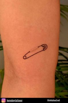 a small tattoo on the back of a woman's leg with a knife in it