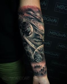 a man with a tattoo on his arm that has an image of saturn and the moon