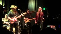 two people on stage playing guitars and singing