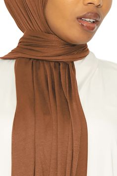 Elevate your outfits in style with our beautiful Jersey Hijab in Bronze. The sumptuously soft fabric is richly colored, has a hint of sheen and just the right amount of stretch. Perfect for any occasion, this hijab is an easy, no-fuss solution for looking pretty in a breeze. Made with luxuriously soft stretch jersey Lightweight and smooth to the touch Measurements: 26Wx72L Made in Dubai Solid Color Hijab For Eid, Versatile Stretch Solid Hijab, Fitted Modest Solid Hijab, Elegant Brown Hijab, Garment Workers, Jersey Hijab, In Dubai, How To Look Pretty, Soft Fabric