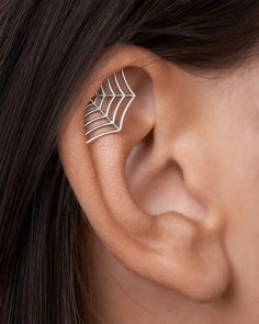 a woman wearing a spider web ear cuff