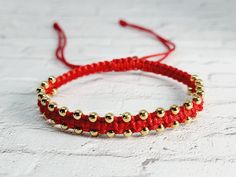 Gold Tone Beads measures 2.5mm (very small beads) 1mm Red String Square Knot with a double row of gold beads woven in.  Red string worn on a person offers a protection against evil eye and negative energy. The gold filled beads offer an elegant touch. Adjustable Red Friendship Bracelets With Spacer Beads, Adjustable Red Friendship Bracelets, Red Friendship Bracelets With Gold Beads As Gift, Red Friendship Bracelet With Gold Beads As Gift, Red Beaded Bracelets With Gold Round Beads, Protection Against Evil Eye, Red String Bracelet, Square Knot, Red String