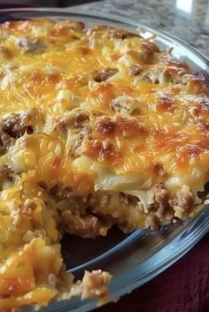 a casserole with meat and cheese is on a glass plate, ready to be eaten