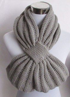 a white mannequin wearing a gray knitted scarf