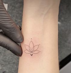 a small lotus tattoo on the wrist