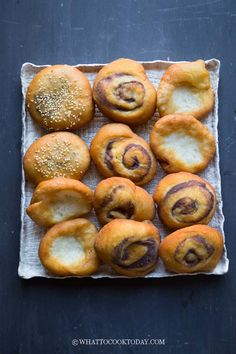 rolls with sesame seeds are arranged on a baking sheet