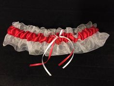 Welcome to GarterShop! Red Sox Inspired Garter Red satin on white organza, adorned with coordinating bows and a Red Sox charm. Garters stretch to 22". Plus size also available, stretching to 30". My bridal garters are handmade using the best quality materials. A wide variety of colors are available. If you don't see the colors you're looking for please contact me. THIS IS NOT A LICENSED PRODUCT.  I AM NOT AFFILIATED WITH THE RED SOX BRAND OR MLB.  THIS PRODUCT IS HANDCRAFTED BY ME WITH LEGALLY PURCHASED LICENSED RED SOX MATERIALS. Prom Garters, Bridal Garters, Wedding Garters, Bridal Garter, Red Satin, Garters, Red Sox, Stretching, Wedding Bridal