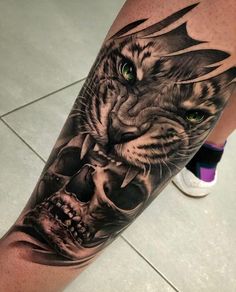 a man's leg with a tiger and skull tattoo on it