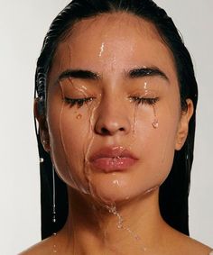 a woman with tears on her face and the water dripping from her eyes is covering her face