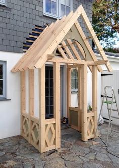 a small wooden house sitting on top of a stone patio