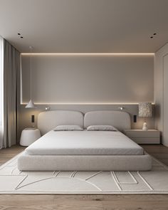 a large white bed sitting in a bedroom next to a wall mounted light above it