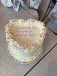 a heart shaped cake on a table with someone's name written in the frosting