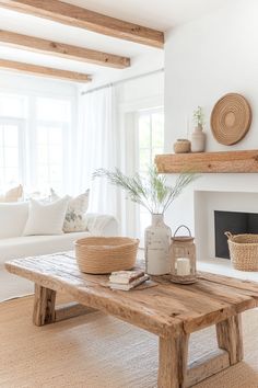 a living room with white walls and wood beams on the ceiling, a fireplace in the background