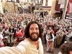 a man taking a selfie in front of a large group of people