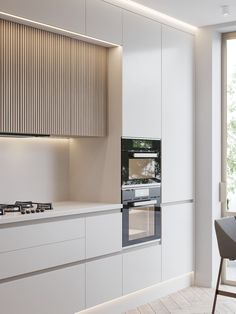 a kitchen with white cabinets and an oven in the center, along with a dining room table