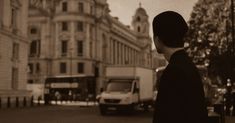 a man standing on the side of a street next to tall buildings