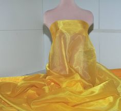 a mannequin with a yellow dress on it's head and some fabric