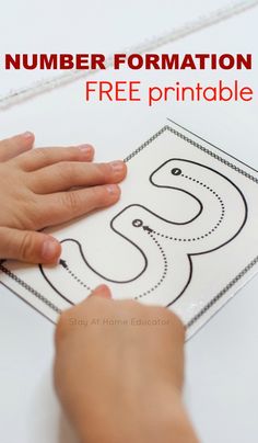 a child's hand on top of a printable number formation