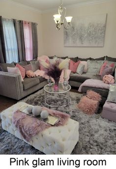 a living room filled with lots of furniture and pink pillows on top of the couches