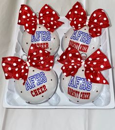 four christmas ornaments with red and white bows on them