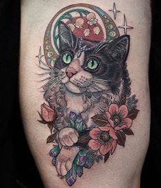 a black and white cat wearing a hat with flowers around it's neck on a woman's thigh