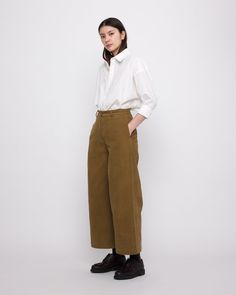 The effortless, menswear inspired Skate Trouser returns this season in an extended length, making it more practical for everyday wear. These trousers sit on the high waist. Features a slight a-line silhouette, wide-leg and ankle length, a sewn-down double pleated detail along the front and zipper fly and button closure. Two side seam pockets and two back pockets. Crafted in a sturdy cotton twill that you will feel secure and held in, these trousers will serve as the foundation for all your fall Knitwear Dress, Friend Outfits, Unisex Accessories, Menswear Inspired, Short Jumpsuit, Sweater Jacket, Ankle Length, Lay Flat, Cotton Twill