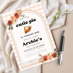 a little pie is turning one birthday party with flowers on the front and side, along with a pen