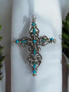 Discover the charm of history with our Vintage Ornate Filigree Cross Pendant. Featuring exquisite faux turquoise set in silver tone, this signed Roma piece is a true testament to Italian craftsmanship. Perfect for adding a touch of vintage elegance to any outfit, this unique pendant speaks of timeless beauty. Whether you're a collector or simply appreciate finely crafted jewelry, this statement piece from Italy is a must-have. Ideal for gifting or personal adornment, celebrate your style authentically with this stunning find. 2.5"x 2" Bohemian Blue Cross Jewelry, Bohemian Turquoise Cross Jewelry, Ornate Turquoise Jewelry For Collectors, Ornate Handmade Turquoise Jewelry, Bohemian Turquoise Cross Pendant Jewelry, Ornate Turquoise Jewelry For Gifts, Ornate Blue Nickel-free Jewelry, Ornate Nickel-free Blue Jewelry, Silver Turquoise Cross Necklace For Gift