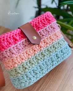 a crocheted purse sitting on top of a wooden table