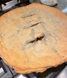 an uncooked pie sitting on top of a metal stove burner in a kitchen