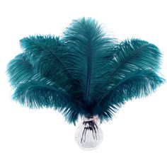 a vase filled with feathers on top of a white table