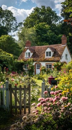 a white house surrounded by flowers and trees