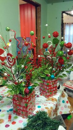 christmas decorations in red and green containers on a table