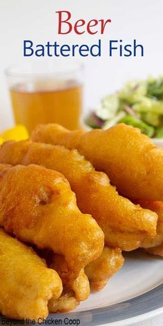 beer battered fish on a white plate next to a salad and glass of beer with the title, beer battered fish