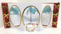 an open christmas card with three oval mirrors on the front and sides, decorated with gold trim