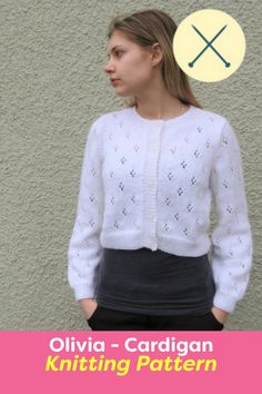 a woman standing in front of a wall wearing a white sweater and black pants with the words, ollivia cardigan yarn design pattern