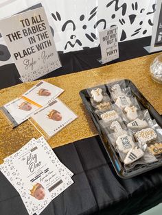 there is a tray of cookies on the table next to some cards and other decorations