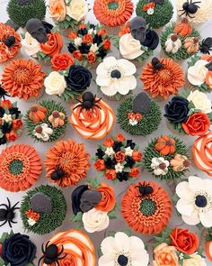 an overhead view of cupcakes decorated with orange and black flowers