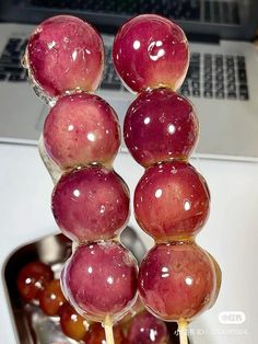 apples are stacked on top of each other in front of a laptop