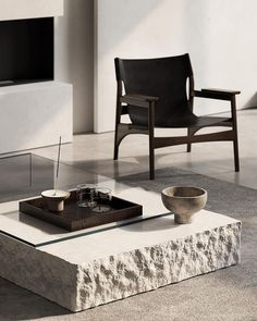 a modern living room with two chairs and a coffee table in the middle of it