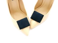 a pair of white high heels with a blue bow