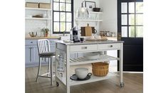 a kitchen island with two chairs and a table on wheels in front of the counter