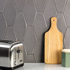 a toaster sitting on top of a counter next to a cutting board