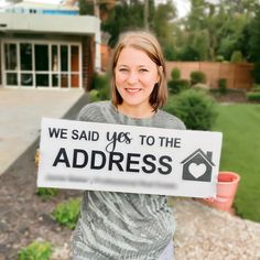 a woman holding up a sign that says we said yes to the address