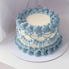 there is a blue and white cake with icing on the top that looks like waves