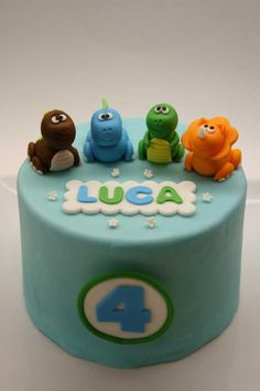 a blue birthday cake with three little animals on top and the number four written in fondant