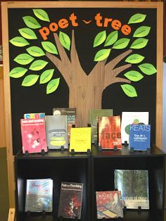 there is a book stand with books on it and a tree painted on the wall